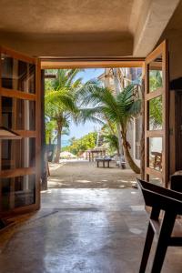 图卢姆La Posada del Sol Boutique Hotel Tulum的通往棕榈树庭院的开放式门