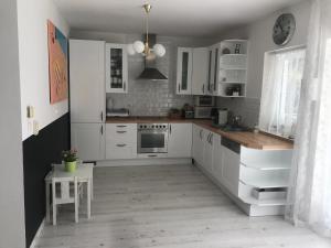 巴拉顿凯奈谢5 bedroom villa very close to Balaton的白色的厨房配有白色的橱柜和桌子