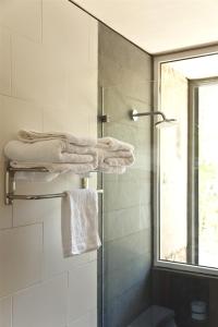 萨帕利亚尔卡萨萨帕拉尔酒店的带淋浴和毛巾的浴室以及窗户。