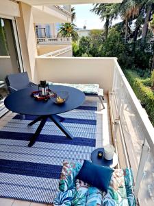 戛纳HENRI CAMILLE REAL ESTATE -Beautiful one bedroom swimming pool and parking的阳台设有带桌子和沙发的庭院。