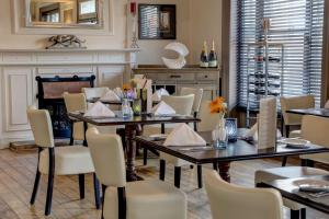 圣赫利尔泽西贝斯特韦斯特皇家酒店的一间带桌椅和壁炉的用餐室