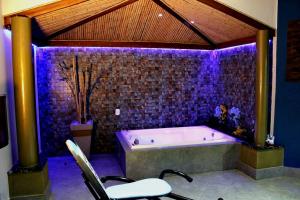 里贝朗普雷托MOTEL COPACABANA的大型浴室设有紫色照明浴缸