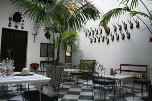 圣玛丽亚港圣巴托洛梅皇宫酒店的一间设有桌椅的用餐室,种植了棕榈树