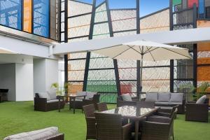 莫尔兹比港Crowne Plaza Residences Port Moresby, an IHG Hotel的庭院配有桌椅和遮阳伞。