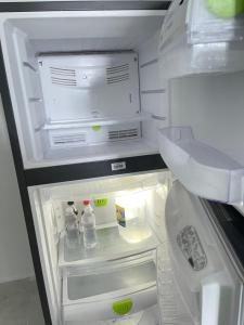 圣地亚哥洛斯卡巴Residencial christall ap 2-A的配有饮料和瓶装水的开放式冰箱