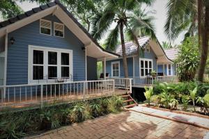 安帕瓦椰青园花园之家度假酒店的蓝色的房子,设有门廊和棕榈树