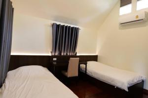 安帕瓦椰青园花园之家度假酒店的客房设有两张床和一张带窗户的书桌。