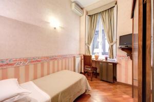 罗马圣莫里茨酒店的酒店客房设有两张床、一张桌子和一台电视。