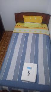 莫约班巴BACHÍG Hospedaje的一张带蓝色和白色条纹棉被的床