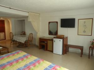 阿劳卡Santa Barbara Arauca的配有床、桌子和电视的房间