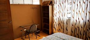 卡哈马卡Departamento Amoblado de estreno con Cochera的一间卧室配有一张床、一张书桌和一个窗户。