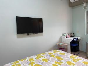 Chaozhou欣园小筑民宿的卧室配有壁挂式平面电视。