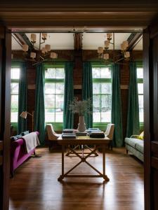 基督城The Observatory Hotel Christchurch的客厅配有桌子和绿色窗帘