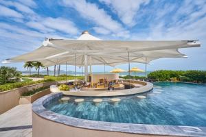 后川Holiday Inn Resort Ho Tram Beach, an IHG Hotel的度假村的游泳池,配有大白伞