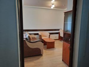 休钦斯克Zhaylau Hotel的客厅配有沙发和桌子