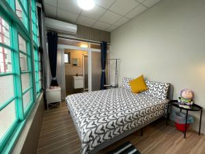 Chaozhou欣园小筑民宿的一间小卧室,配有床和黄色枕头