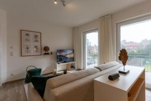 奥斯赛拜-屈隆斯博恩App 22, Strandresidenz Dünenperle的带沙发和大窗户的客厅