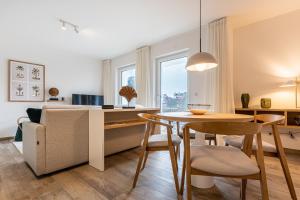 奥斯赛拜-屈隆斯博恩App 22, Strandresidenz Dünenperle的厨房以及带桌子和沙发的客厅。