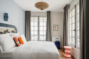 巴黎Edgar Suites Louvre - Jour的卧室设有白色大床和窗户。