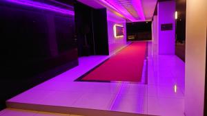 北九州Hotel LOVE MODERN的地板上带紫色灯的走廊