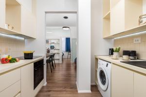 里耶卡Apartmani Artqart Rijeka的厨房配有白色橱柜、洗衣机和烘干机