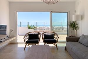 加的斯INFINITY Sunny Home by Cadiz4Rentals的带沙发和椅子的客厅以及大窗户。