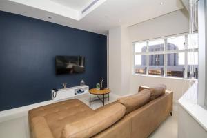 开普敦2010 Pullman Lovely 2 Bedroom apartment in the CBD的客厅里设有一张大沙发,拥有蓝色的墙壁
