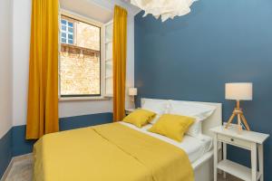 杜布罗夫尼克Kenova apartment Old Town的蓝色的卧室设有黄色的床和窗户