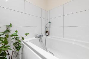 布雷得佛Stylish 2 bed apartment close to city的浴室设有带淋浴喷头的浴缸。