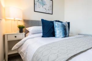 布雷得佛Stylish 2 bed apartment close to city的一间卧室配有一张带蓝色枕头的床