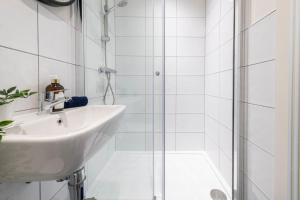 布雷得佛Stylish 2 bed apartment close to city的白色的浴室设有水槽和淋浴。