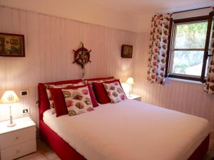 MaladrosciaAppartamento in villa panoramica Maladroxia的一间卧室配有一张带红色枕头的大床