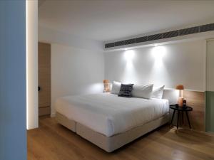 悉尼邦迪QT公寓式酒店的白色卧室配有一张带白色枕头的大床