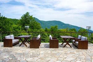 哈尼亚Manthos Mountain Resort & Spa的庭院配有桌椅,背景为山脉