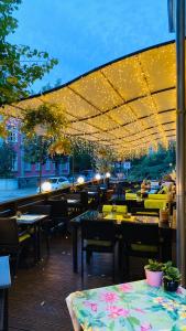 拉德博伊尔ZU DEN LINDEN - RADEBEUL Pension mit Restaurant的餐厅庭院配有桌椅和灯光