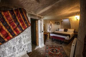 格雷梅Avilla Cave Hotel的石头间内一间卧室,配有一张床