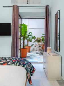 圣玛丽亚港Art Suites by Casa de Indias的一间卧室设有一张床和一个植物阳台