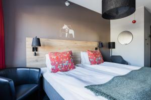 莫拉圣米卡埃尔酒店的一间卧室配有一张带红色枕头的床和一把椅子