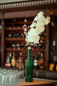 DoloresHotel Argon的绿花瓶,桌子上放着白色花