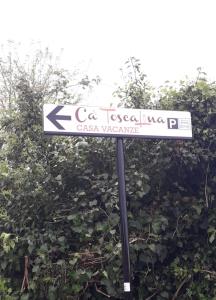 卡拉拉Ca' ToscaLina的灌木丛前的白色街道标志