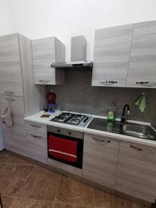 维亚格兰德Loft San Mauro的厨房配有白色橱柜、炉灶和水槽。