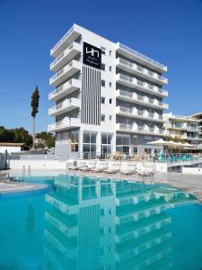马蒂NLH Mati Seafront - Neighborhood Lifestyle Hotels的大楼前设有游泳池的酒店