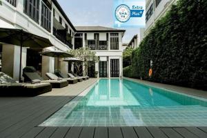 清迈99号遗产酒店-SHA Extra Plus Certified的一座建筑物中央的游泳池