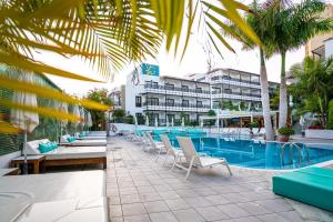 美洲海滩Vanilla Garden Boutique Hotel - Adults Only的一个带游泳池和椅子的度假胜地和一座建筑