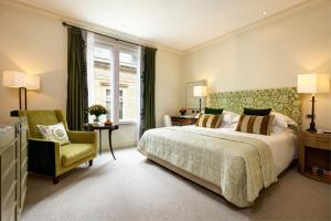 布鲁塞尔阿米戈罗科富酒店的卧室配有床、椅子和窗户。