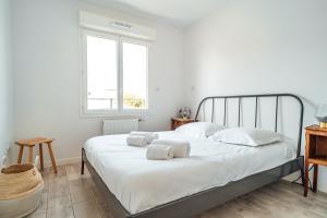拉特斯特德布赫SEAHORSE - Spacieux Appartement proche du port de la Teste的一间卧室配有带白色床单和枕头的床。