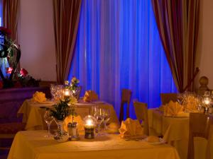 科戈洛多米纳帕尔科德罗斯泰尔维奥酒店的一间设有两张桌子和蓝色窗帘的用餐室