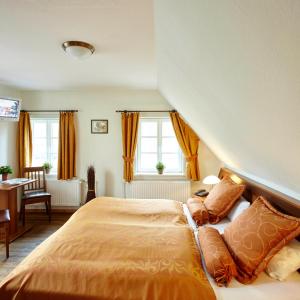 Behringen豪弗图斯伯格酒店的一间卧室配有带橙色床单和枕头的床。