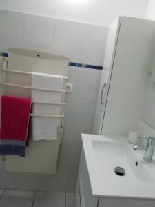 HillionANCRE BLEU的白色的浴室设有水槽和红色毛巾