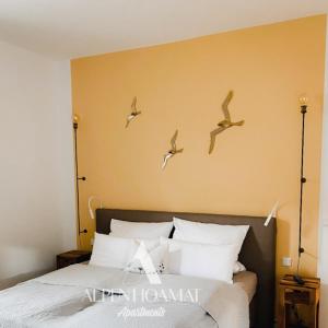 加尔米施-帕滕基兴Alpenhoamat Apartments的一间卧室,床上方有鸟飞翔